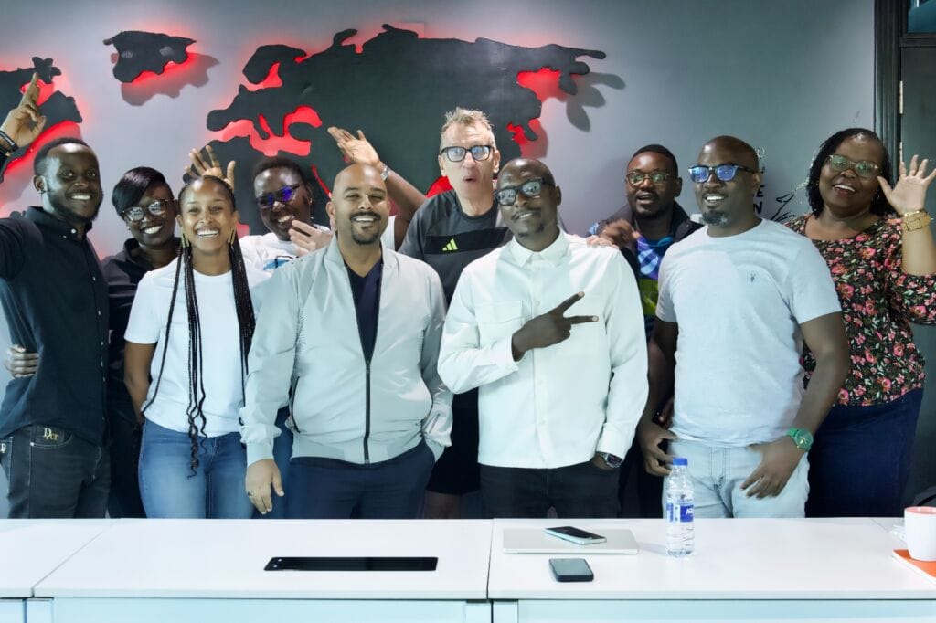 Julius Kyazze posing for a photo with NRG management
